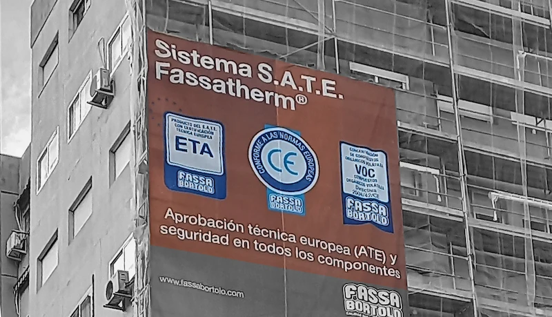 Andamiso en la fachada de un edificio con pancarta del sistema S.A.T.E